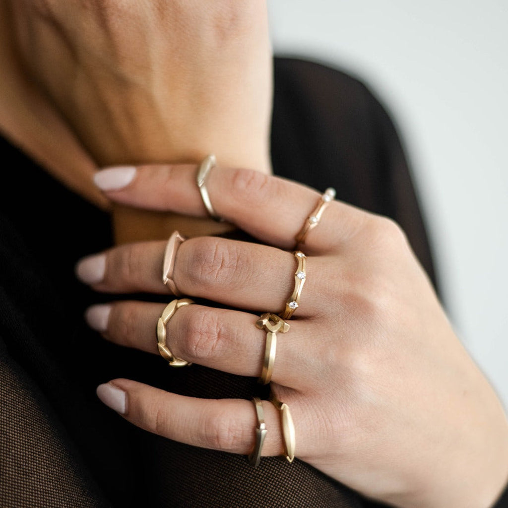 hand wearing multiple gold and diamond rings from Nikki Lorenz Designs