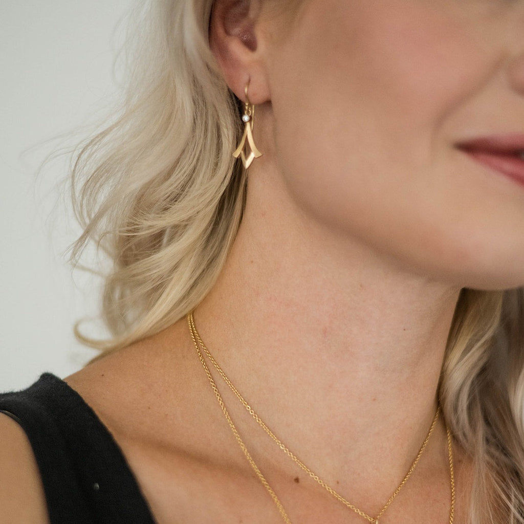 woman wearing trumpet shaped gold and diamond earring from Nikki Lorenz Designs