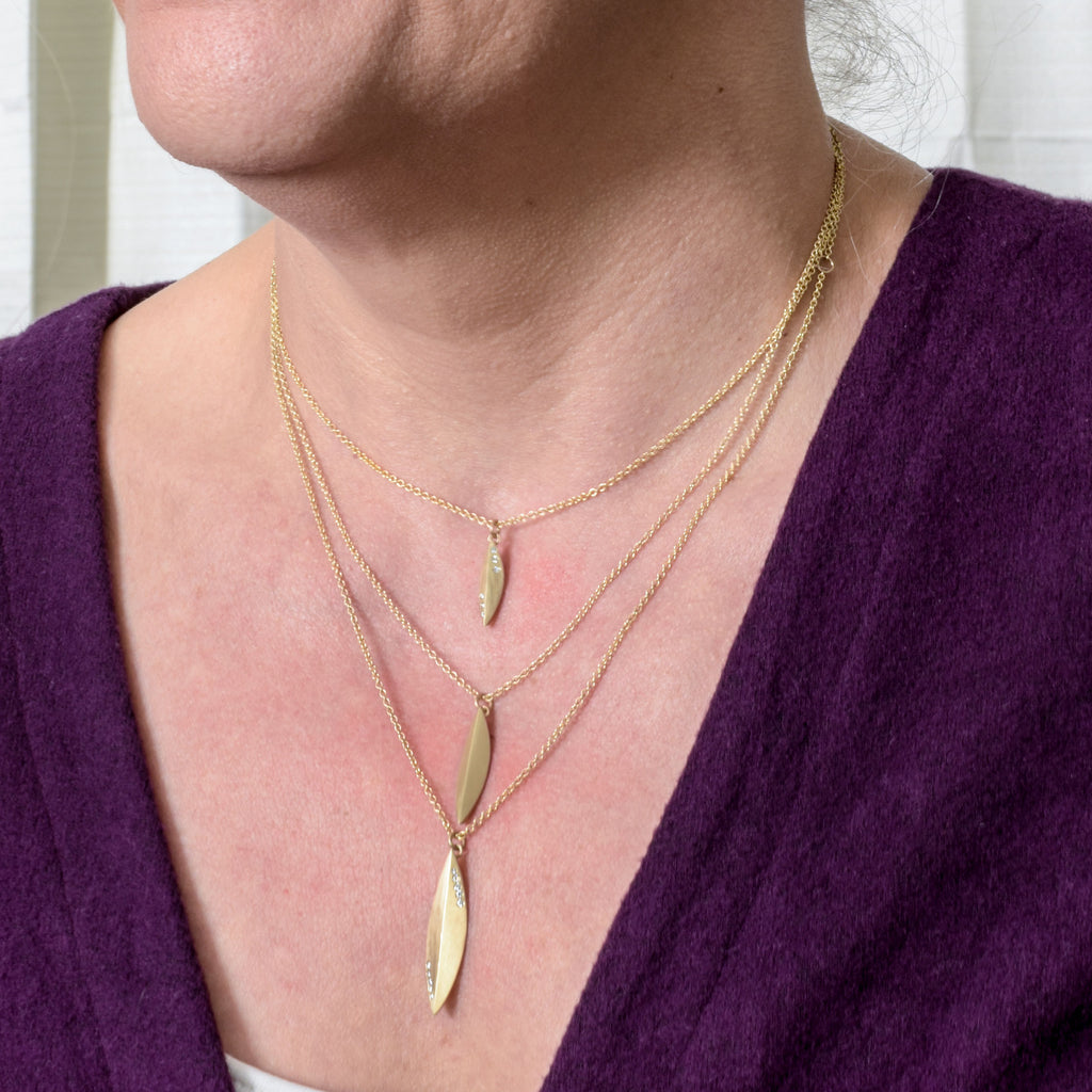 model wearing 14k gold and diamond elongated pendants from Nikki Lorenz Designs