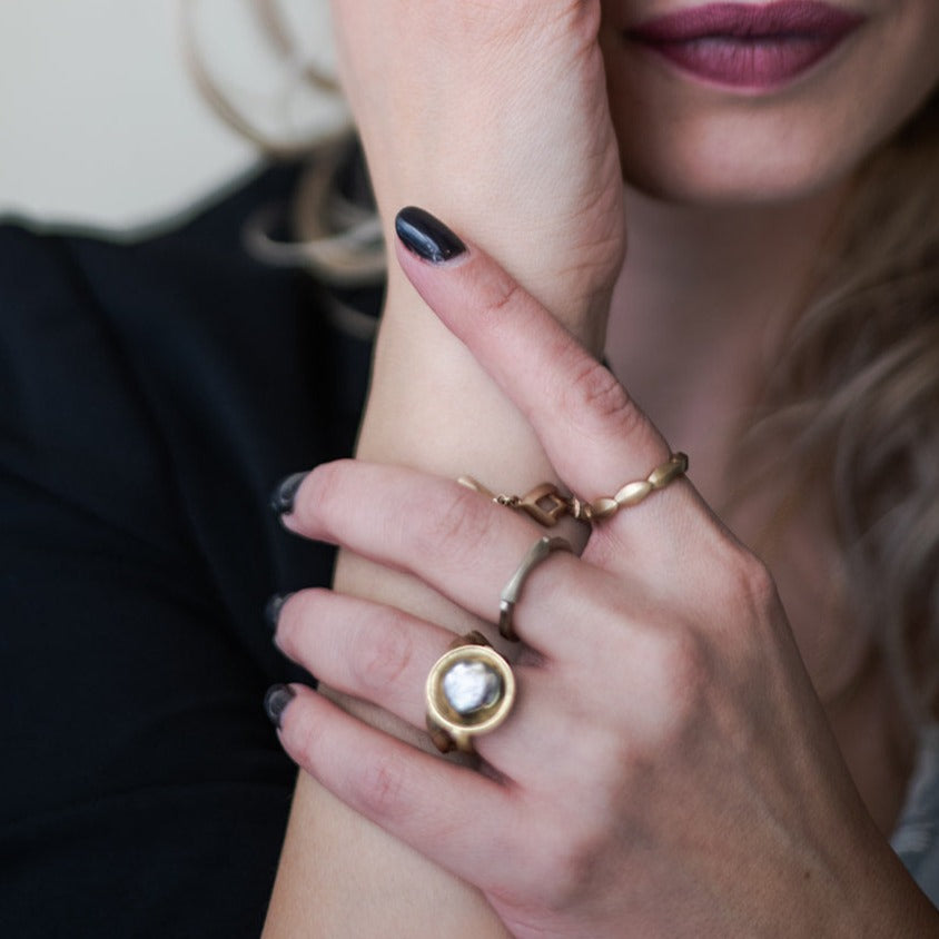woman with dark nails wearing 3 gold stacking rings from Nikki Lorenz Designs