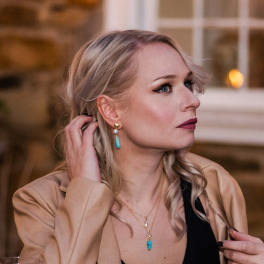 woman wearing gold, pearl, and amazonite earrings with a turquoise gold necklace from Nikki Lorenz Designs