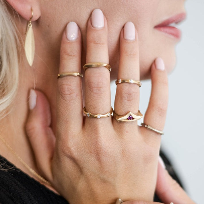 model wearing gold and diamond rings Nikki Lorenz Designs