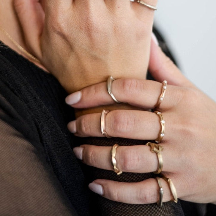close-up of woman wearing multiple gold stacking rings