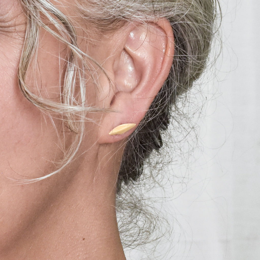 model wearing small modern gold stud earrings from Nikki Lorenz Designs