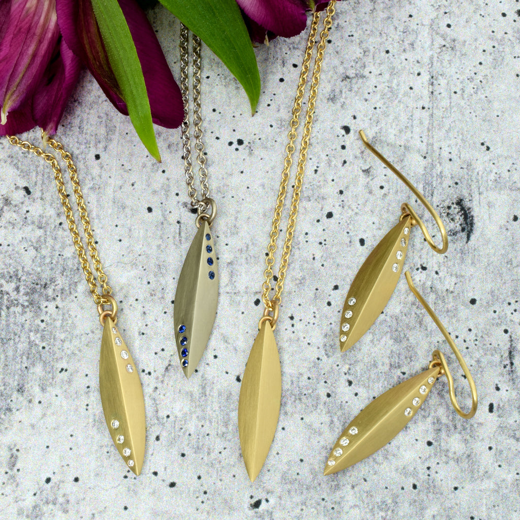 grouping of elongated pendants and earrings with diamonds and sapphires from Nikki Lorenz Deisgns